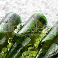 three green beer bottles in the ice