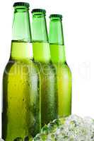 three green beer bottles with ice isolated over white background