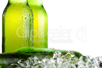 three green beer bottles with ice
