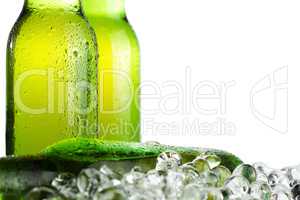 three green beer bottles with ice