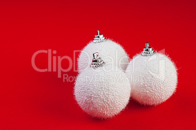 three white christmas balls on red background