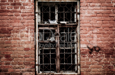 wall of a deserted house with smashed window