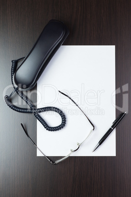 blank sheet of paper on the table with a pen, glasses and teleph