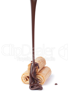 chocolate pouring onto waffle roll isolated on white