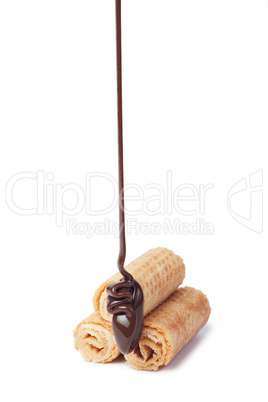 chocolate pouring onto waffle roll isolated over white