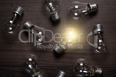 glowing bulb over wooden background uniqueness concept