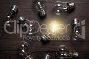 glowing bulb over wooden background uniqueness concept