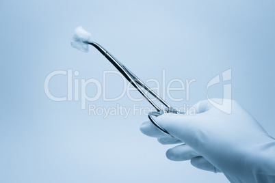 hand of surgeon with forceps during surgery