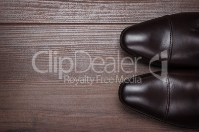 man in brown shoes standing on the wooden floor background
