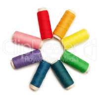 rainbow colored set of threads over white background