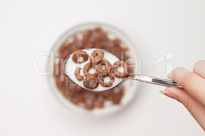 spoon full of chocolate ringlets in hand close-up breakfast conc