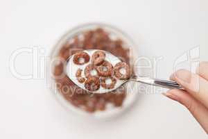 spoon full of chocolate ringlets in hand close-up breakfast conc