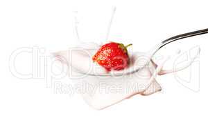 strawberry splashing into the spoon full of yoghurt