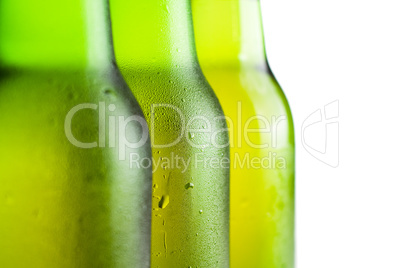 three green beer bottles over white background