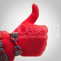 thumb up in red glove over grey background