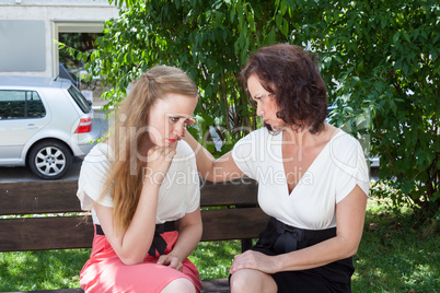 Zwei Frauen, in einem herzlichen Gespräch auf einer Bank