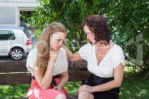 Zwei Frauen, in einem herzlichen Gespräch auf einer Bank