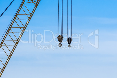 Pair of industrial crane hoists on cables near truss