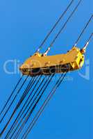 Large yellow pulley and cable assembly on blue sky