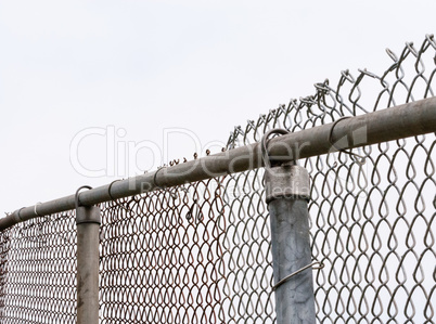 Top of old chain-link fence and posts on white