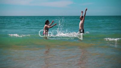 Happy Couple Having Fun on Ocean Waves, slow motion