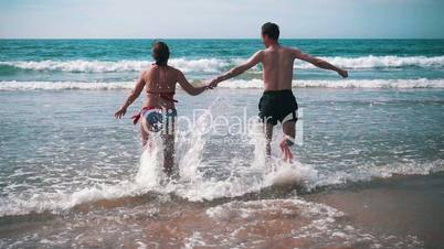 Happy Couple Having Fun on Ocean Waves, slow motion