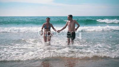 Happy Couple Having Fun on Ocean Waves, slow motion