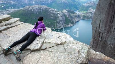 Woman looking at the landscape from a height. Beautiful Nature Norway Preikestolen or Prekestolen.