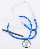 Stethoscope with clean sheet and pen on a white background