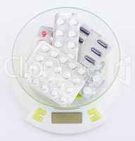 Pills in blister lying on an electronic balance