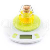 Bottle of olive oil stands on kitchen electronic scales