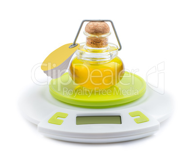 Bottle of olive oil stands on kitchen electronic scales