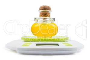 Bottle of olive oil stands on kitchen electronic scales