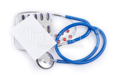 Stethoscope and pills with a white sheet of paper for recipes