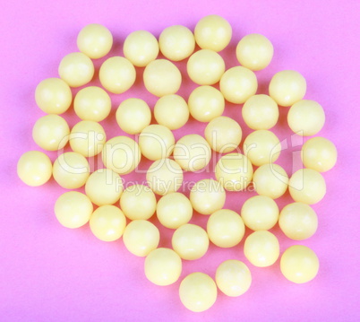 yellow vitamins on pink background