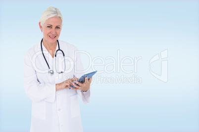 Composite image of smiling female doctor using table computer