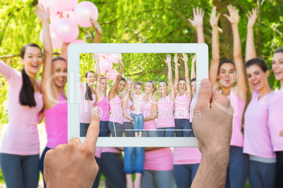 Composite image of hand holding tablet pc