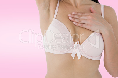 Composite image of woman in bra with breast cancer awareness rib