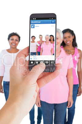 Composite image of female hand holding a smartphone