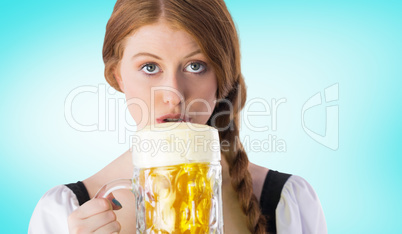 Composite image of oktoberfest girl drinking jug of beer