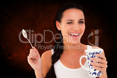 Composite image of pretty brunette having cup of tea