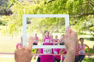 Composite image of hand holding tablet pc