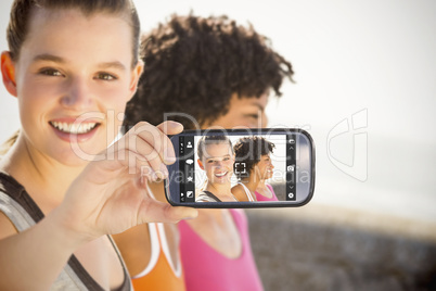 Composite image of hand holding smartphone showing