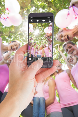 Composite image of female hand holding a smartphone