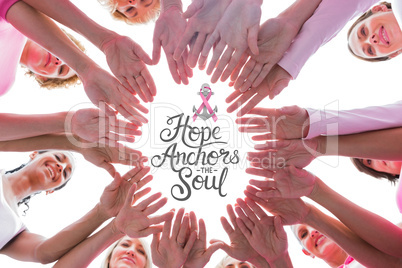 Composite image of happy women in circle wearing pink for breast