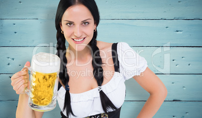 Composite image of pretty oktoberfest girl holding beer tankard