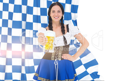 Composite image of pretty oktoberfest girl holding beer tankard