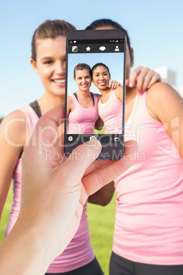 Composite image of female hand holding a smartphone