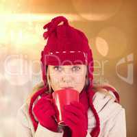 Composite image of happy blonde in winter clothes holding mug