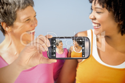 Composite image of hand holding smartphone showing